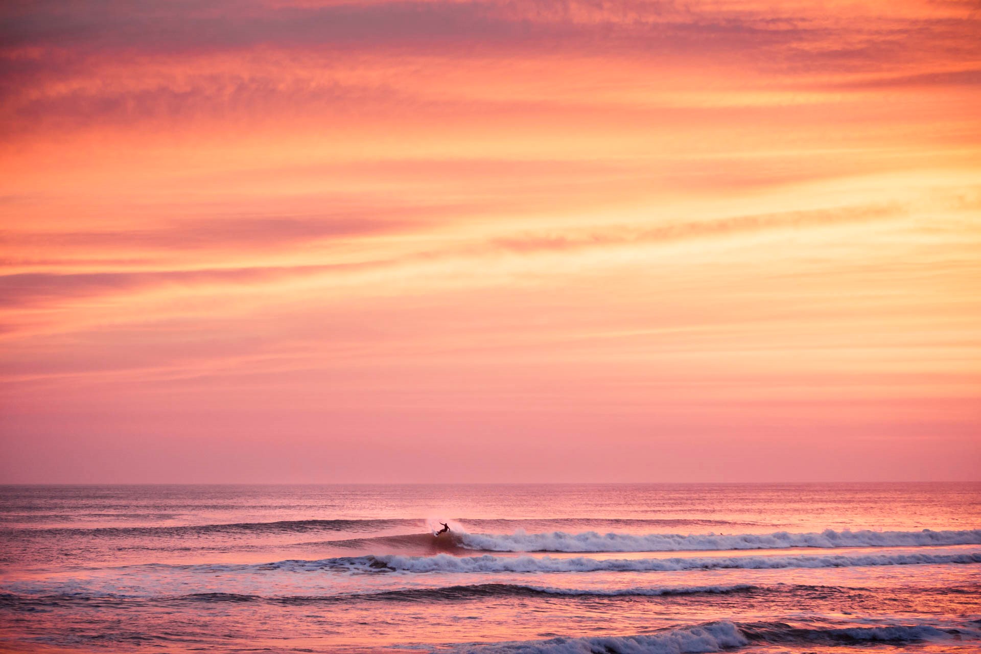 Surfing under the pink sky light